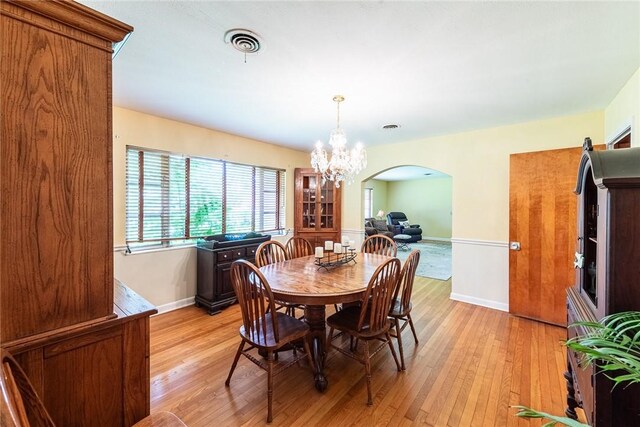 177 Pinewood St, Folkston, GA 31537 - dining space with arched walkways, light wood finished floors, and a chandelier