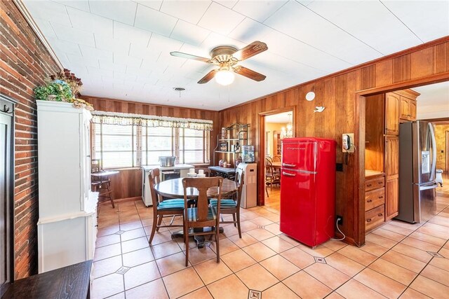 177 Pinewood St, Folkston, GA 31537 - dining space with ceiling fan, wood walls, light tile patterned floors, and brick wall