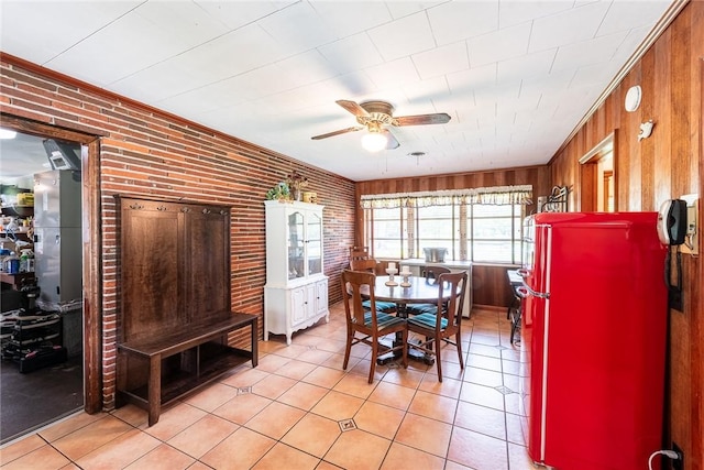 177 Pinewood St, Folkston, GA 31537 - dining area featuring light tile patterned flooring, a ceiling fan, brick wall, and wooden walls