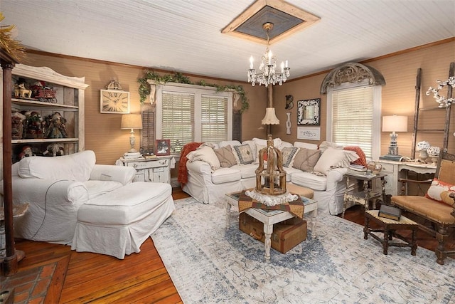 living room featuring crown molding, a chandelier, and wood finished floors