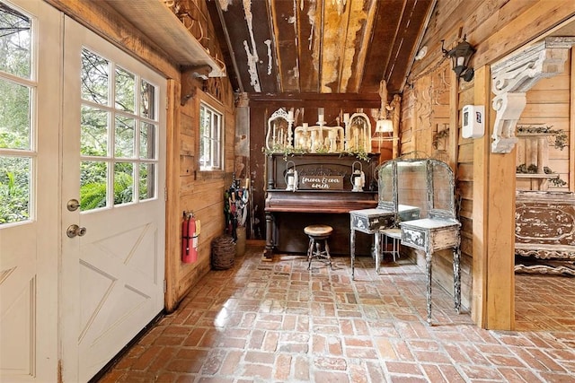 interior space featuring brick floor and wooden walls