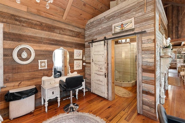 home office with a barn door, wood walls, wood finished floors, and wood ceiling