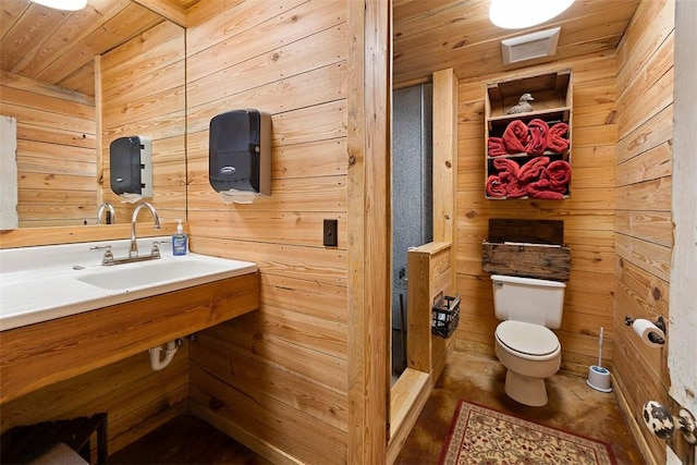 half bathroom with toilet, wooden ceiling, wooden walls, and a sink