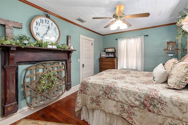 bedroom with visible vents, a ceiling fan, ornamental molding, dark wood-type flooring, and a fireplace