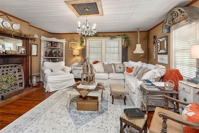 living area with a notable chandelier, ornamental molding, and wood finished floors