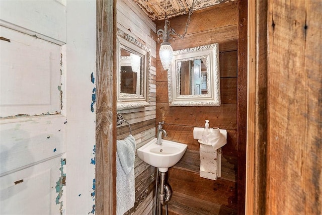 bathroom featuring a sink and wooden walls