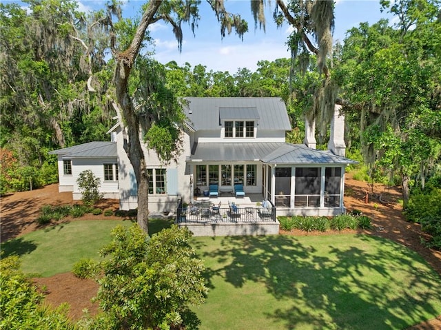 49 Hatton Ln, Saint Simons Island, GA 31522 - back of property with a sunroom, a lawn, a patio, an outdoor hangout area, and metal roof