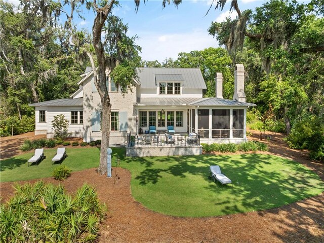 49 Hatton Ln, Saint Simons Island, GA 31522 - rear view of property with a sunroom, a yard, a standing seam roof, and a patio area