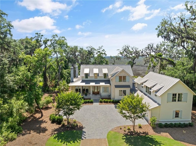 49 Hatton Ln, Saint Simons Island, GA 31522 - view of front of house with a standing seam roof, metal roof, driveway, and covered porch
