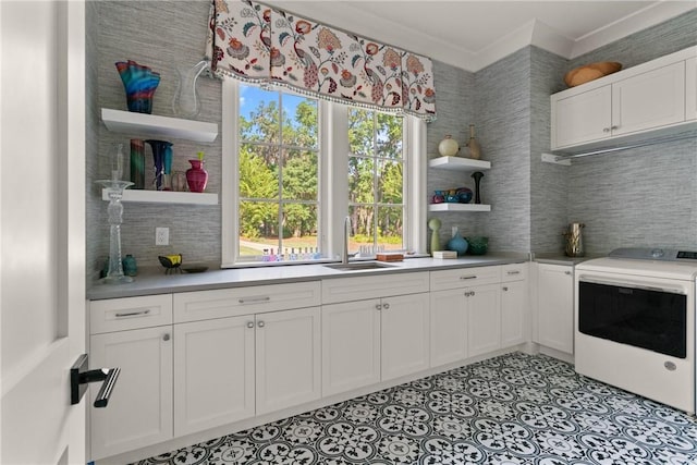 49 Hatton Ln, Saint Simons Island, GA 31522 - kitchen featuring open shelves, washer / dryer, a sink, and white cabinetry