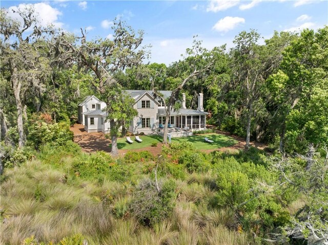 49 Hatton Ln, Saint Simons Island, GA 31522 - rear view of property featuring a sunroom, a lawn, and view of scattered trees