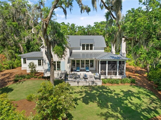 49 Hatton Ln, Saint Simons Island, GA 31522 - back of property with a sunroom, a lawn, a patio, an outdoor hangout area, and metal roof