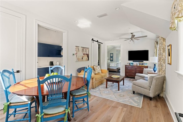 49 Hatton Ln, Saint Simons Island, GA 31522 - dining area with a barn door, a ceiling fan, light wood-type flooring, lofted ceiling, and baseboards