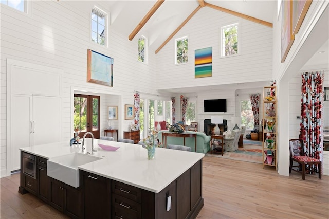 49 Hatton Ln, Saint Simons Island, GA 31522 - kitchen featuring a sink, high vaulted ceiling, light wood-type flooring, light countertops, and french doors