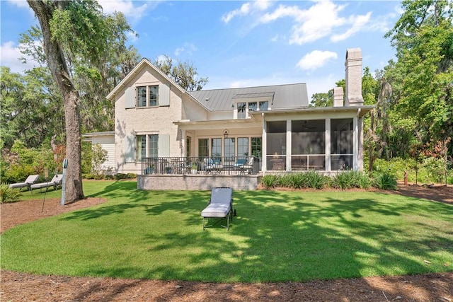 49 Hatton Ln, Saint Simons Island, GA 31522 - back of property featuring a chimney, a yard, a sunroom, metal roof, and a standing seam roof
