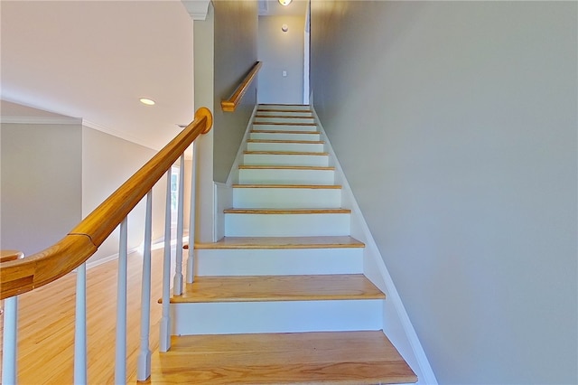 staircase with recessed lighting, baseboards, ornamental molding, and wood finished floors