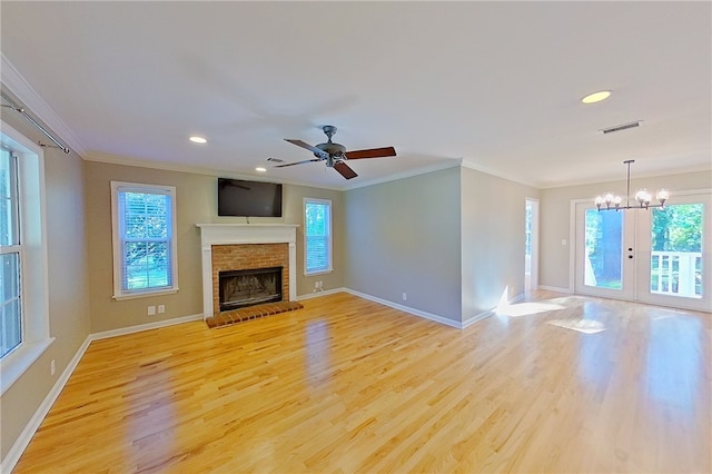 unfurnished living room with visible vents, ornamental molding, light wood-style flooring, and a healthy amount of sunlight