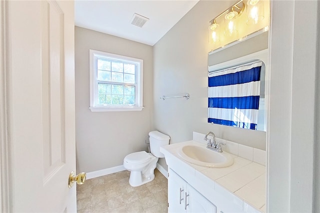 bathroom featuring baseboards, vanity, toilet, and visible vents