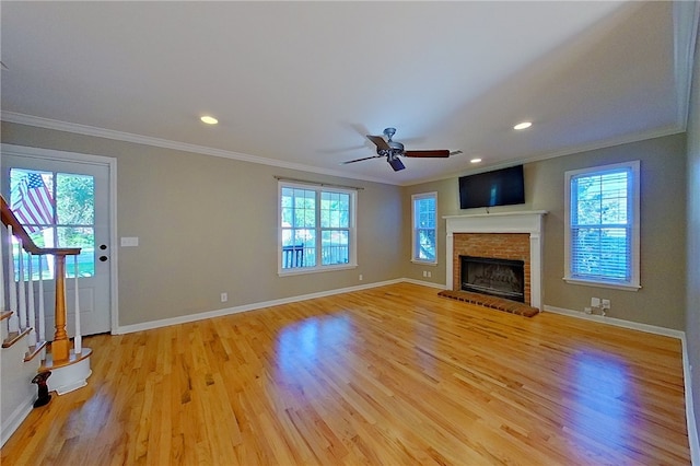 unfurnished living room featuring stairway, baseboards, ornamental molding, and light wood finished floors