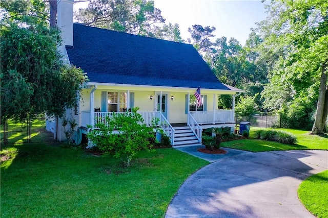 view of front of house with a porch, a chimney, and a front lawn