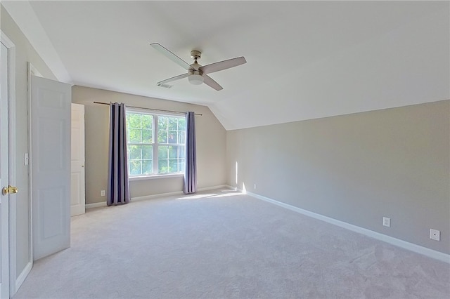 additional living space with baseboards, ceiling fan, light carpet, and vaulted ceiling