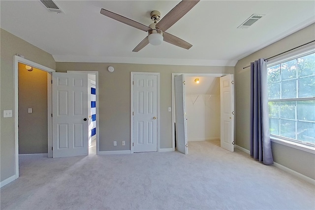 unfurnished bedroom featuring baseboards, light colored carpet, and visible vents