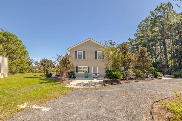 view of front of property featuring a front yard and a patio area