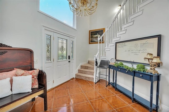 tiled foyer entrance with a chandelier and a towering ceiling