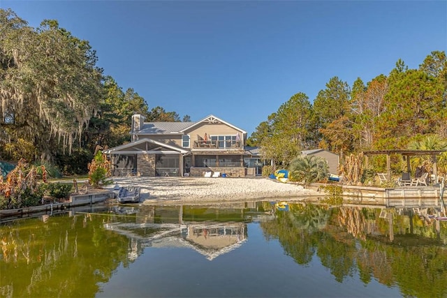 rear view of property featuring a water view and a balcony