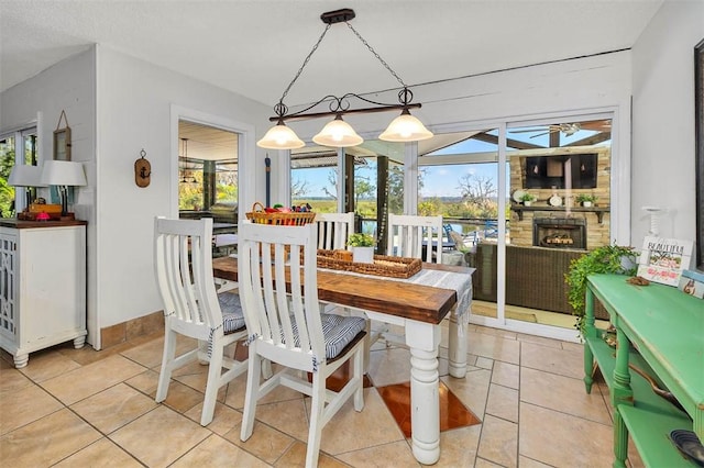 dining area with light tile patterned floors and a fireplace