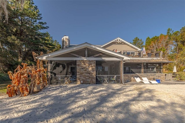 rear view of property with a balcony and a sunroom