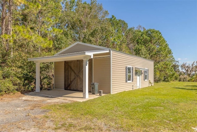 view of outbuilding with a yard and a carport