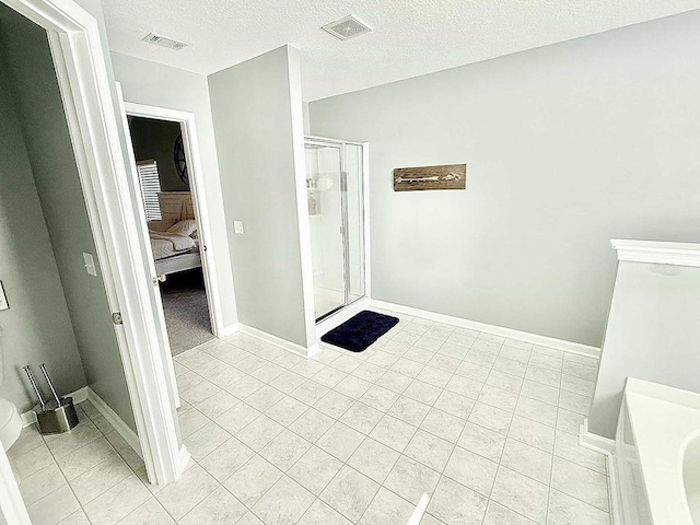 272 NE Whippoorwill Way, Ludowici, GA 31316 - ensuite bathroom featuring connected bathroom, a textured ceiling, tile patterned floors, a shower stall, and visible vents