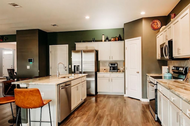 272 NE Whippoorwill Way, Ludowici, GA 31316 - kitchen featuring white cabinets, stainless steel appliances, a sink, and tasteful backsplash
