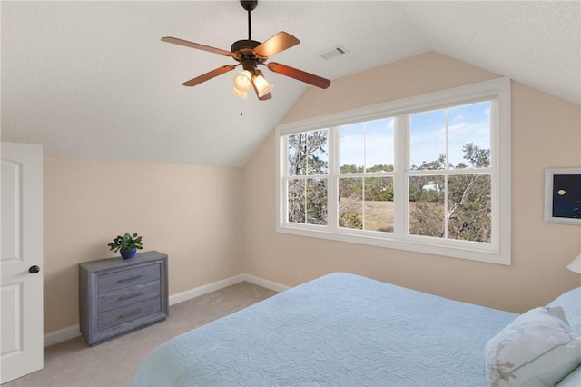 carpeted bedroom featuring lofted ceiling, a textured ceiling, and ceiling fan