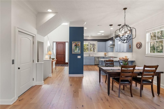 dining room featuring an inviting chandelier, crown molding, and light hardwood / wood-style floors