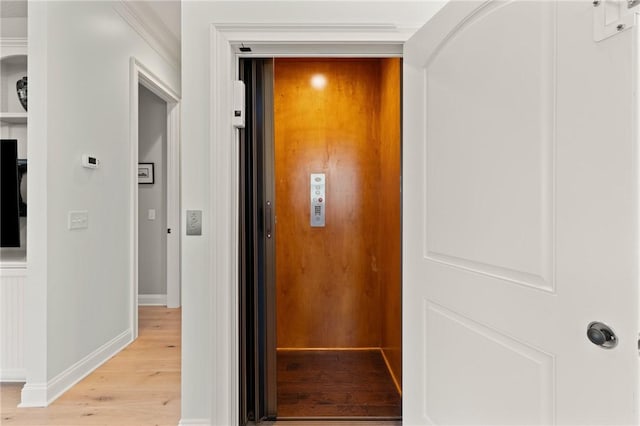 hall featuring elevator and light wood-type flooring