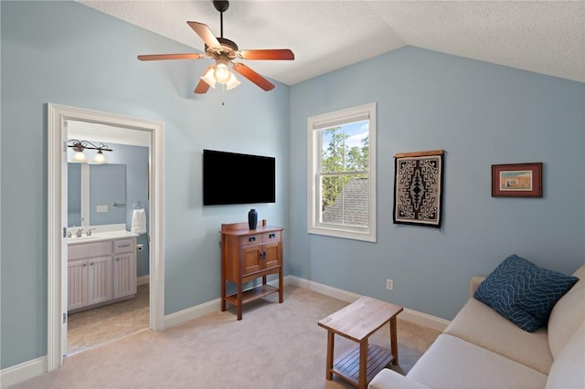 living room featuring lofted ceiling, sink, light colored carpet, ceiling fan, and a textured ceiling