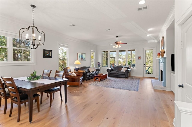 dining space with crown molding, ceiling fan with notable chandelier, and light hardwood / wood-style floors