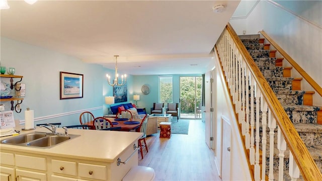 1175 N Beachview Dr Unit 389, Jekyll Island, GA 31527 - kitchen featuring pendant lighting, open floor plan, light countertops, a sink, and light wood finished floors