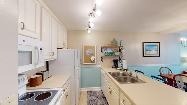 kitchen with white appliances, rail lighting, sink, light tile patterned floors, and a chandelier