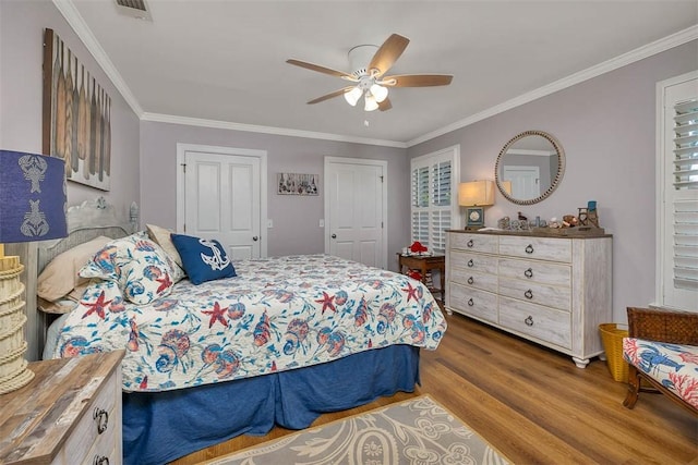 bedroom with wood finished floors, ornamental molding, and a ceiling fan