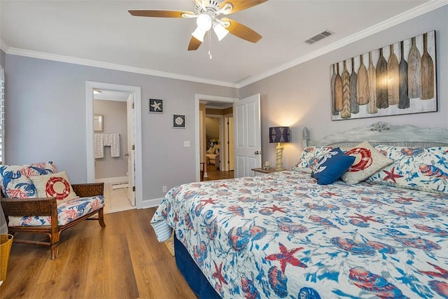 bedroom with ornamental molding, wood finished floors, ceiling fan, ensuite bath, and baseboards