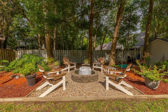 view of patio / terrace featuring a fenced backyard, an outdoor fire pit, a shed, and an outdoor structure