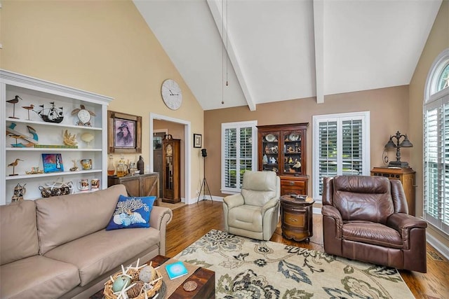 living room with wood finished floors, baseboards, high vaulted ceiling, and beam ceiling
