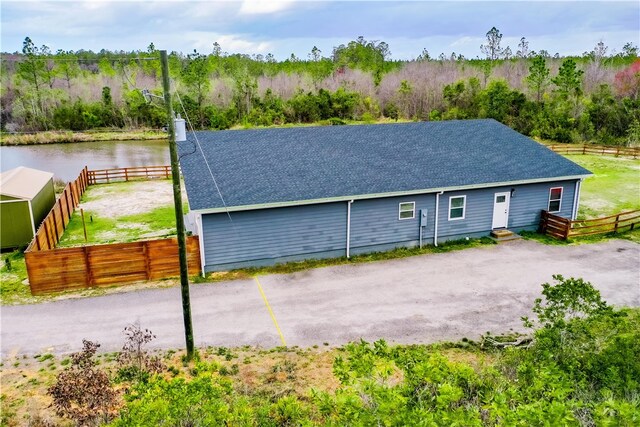 3935 Memorial Dr, Waycross, GA 31503 - view of front of property with uncovered parking, roof with shingles, a water view, and fence