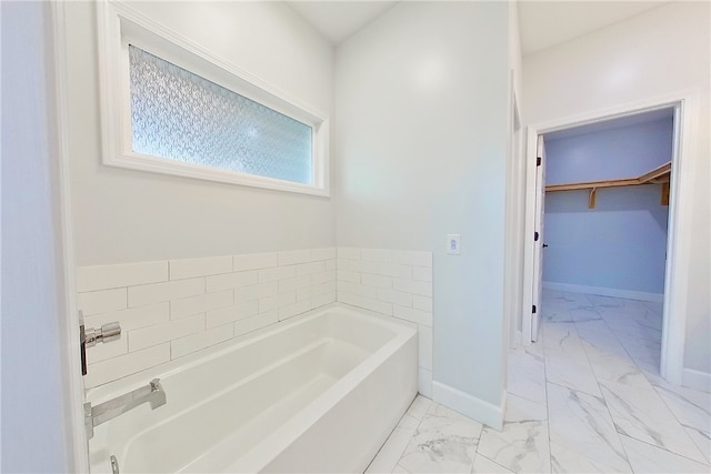 3935 Memorial Dr, Waycross, GA 31503 - bathroom featuring marble finish floor, a spacious closet, baseboards, and a garden tub
