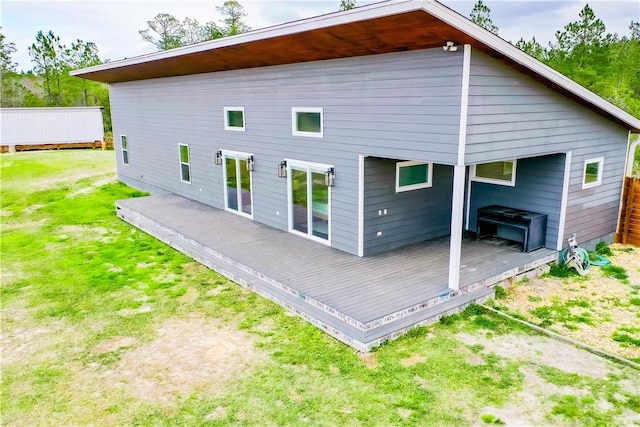 back of house with a deck and a yard