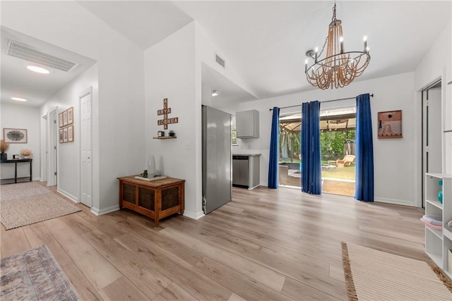 entryway with visible vents, light wood finished floors, baseboards, and a chandelier