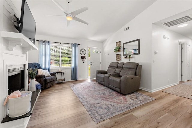 living room featuring visible vents, ceiling fan, vaulted ceiling, and light wood-type flooring